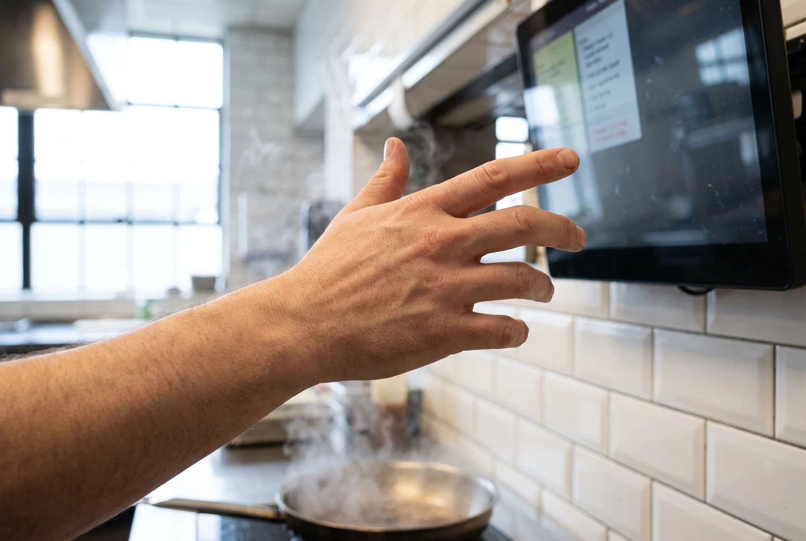 Hands lifting a ticket at the kitchen pass